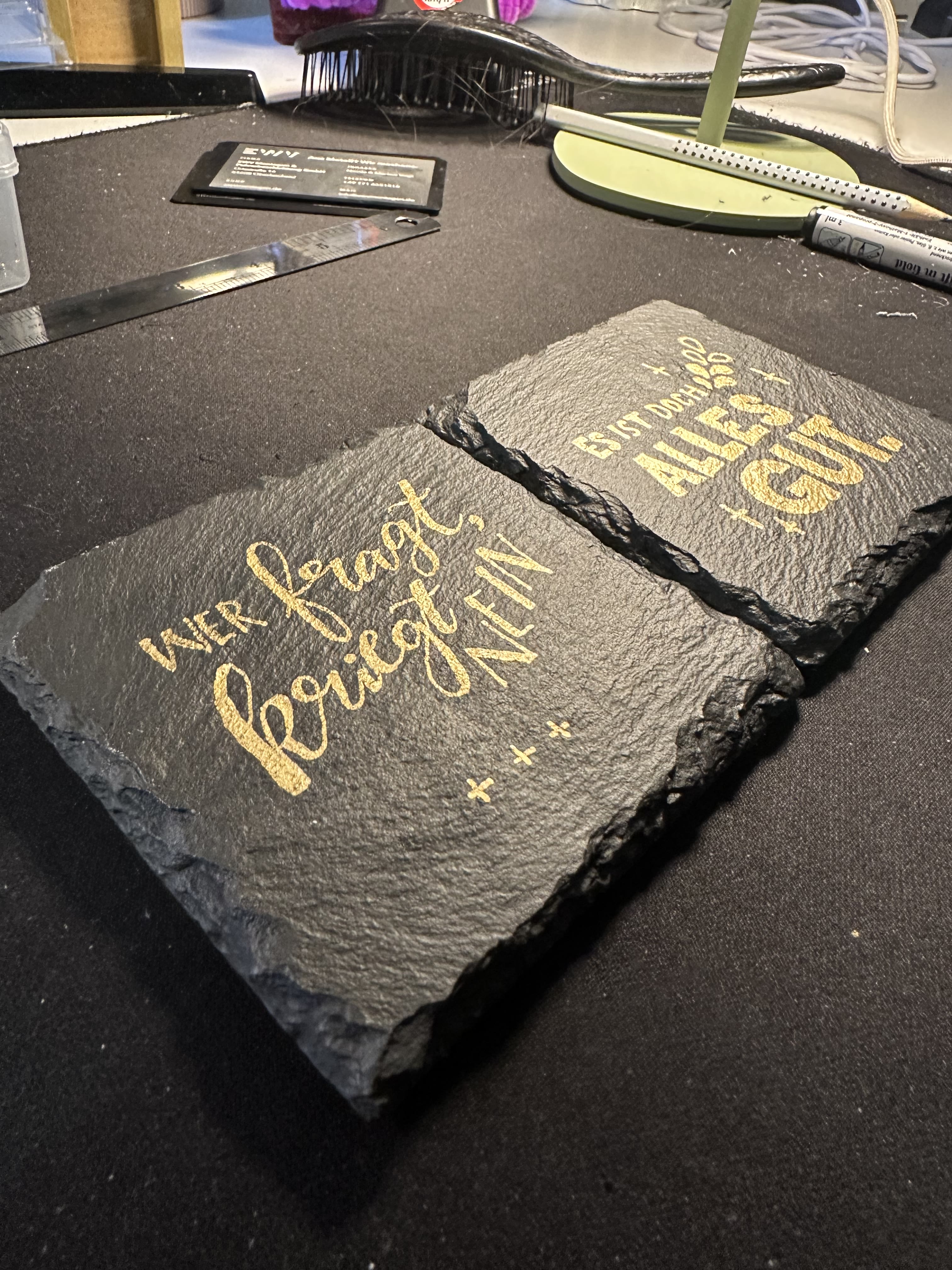 Werkstattfoto: Lackstift und Lasergravur auf Schiefer
