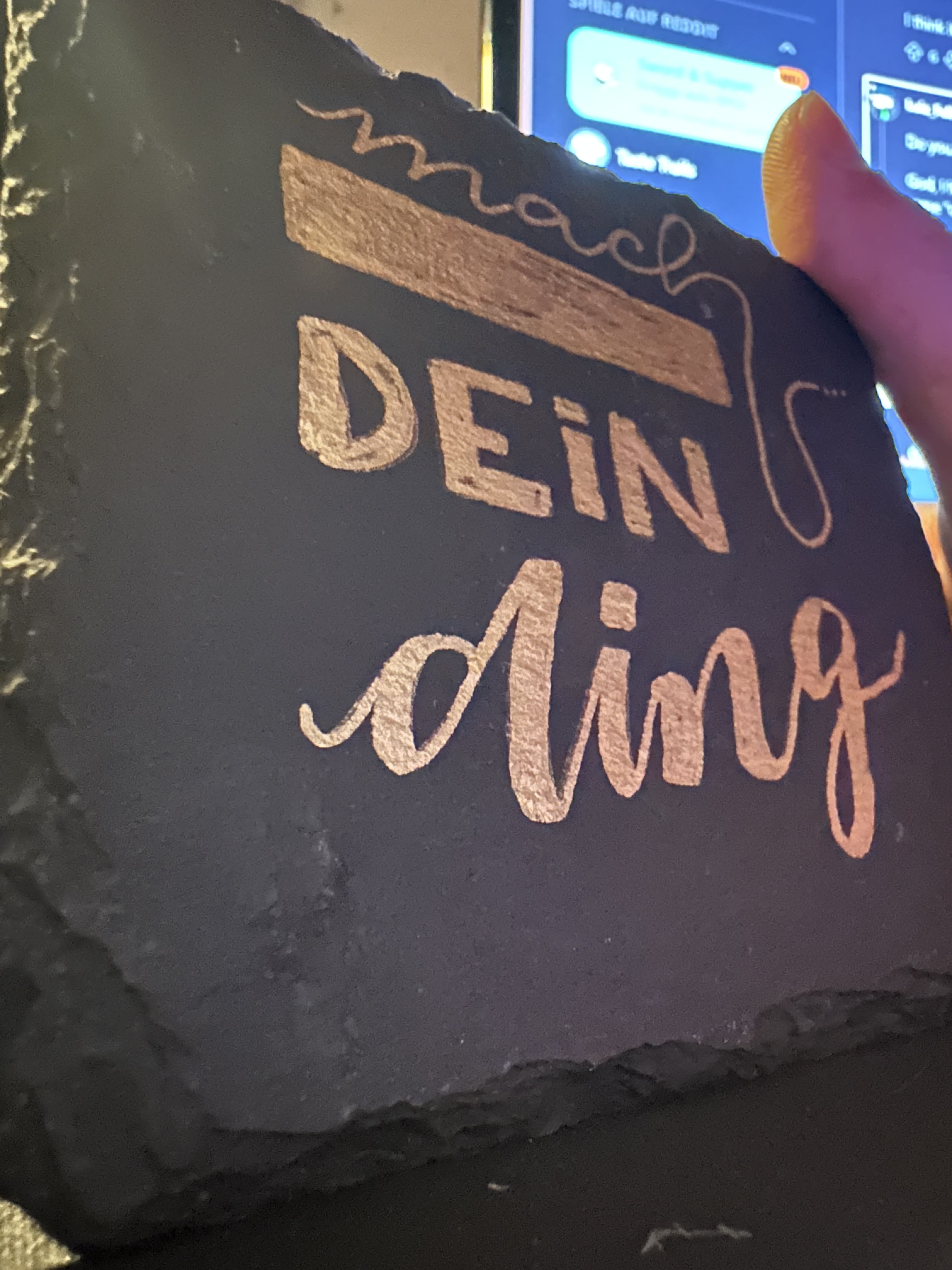 Werkstattfoto: Lackstift und Lasergravur auf Schiefer